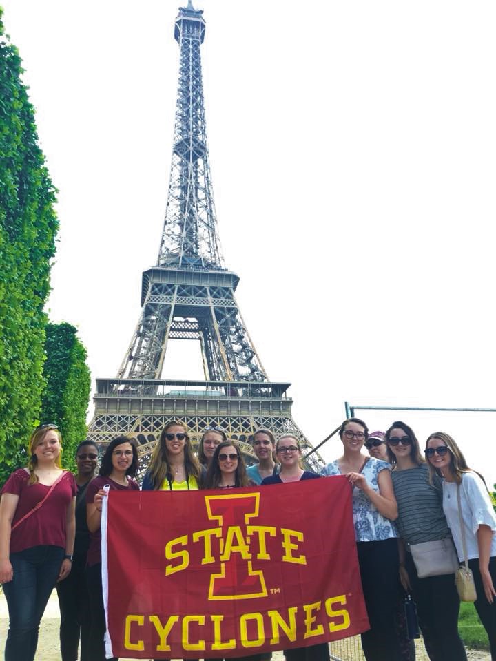 Students holding an ISU flag in front of the eiffel tower in france